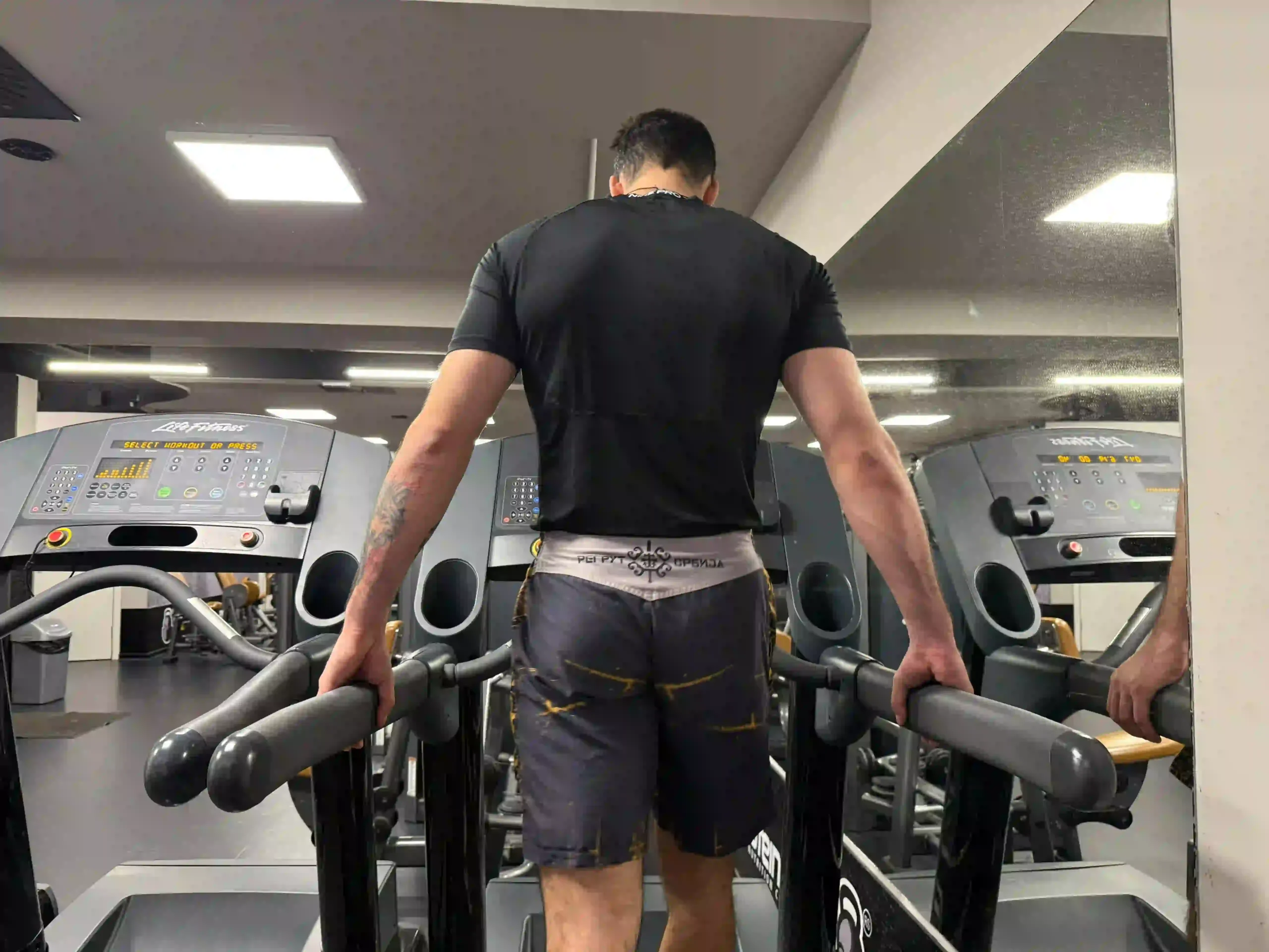 anja demonstrating the common mistake of gripping treadmill handrails, which reduces workout effectiveness and affects posture.