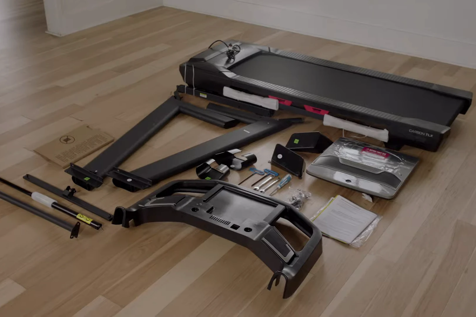 treadmill parts Treadmill parts laid out on the floor before assembly – running deck, frame pieces, console, tools and hardware components