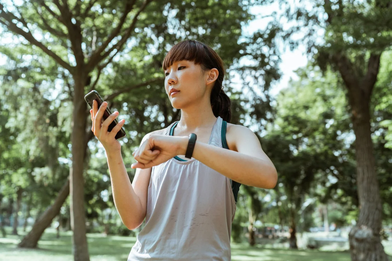 Woman checking her fitness tracker while exercising outdoors