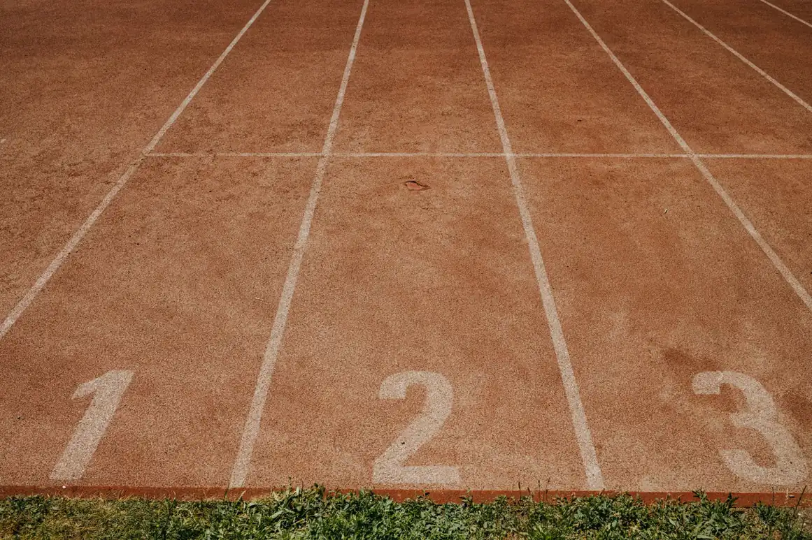 Red running track with painted lane numbers one, two, and three at the start