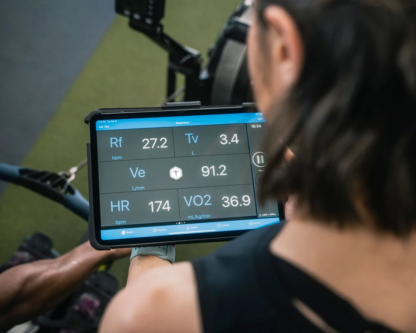 Athlete checking heart rate and VO2 readings on a tablet mid workout