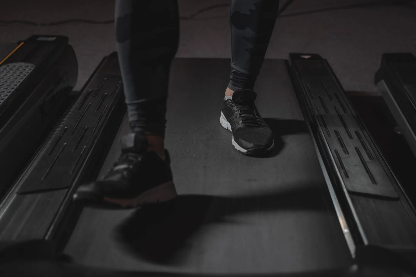 Close-up of sneakers walking on a treadmill belt in a gym