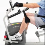 Man using the Innova RCT2025 recumbent cross trainer, side profile, showing the leg harness in use