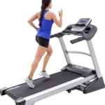 Woman running on Spirit XT385 treadmill, rear angle