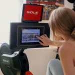 Close-up of the Sole rower large touchscreen console showing the workout class library, SOLE branding only, no model number visible