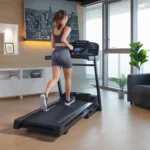 Woman running on the XTERRA TR65 Sport Series treadmill, rear angle with console display visible