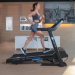 Woman running on the XTERRA TR65 Sport Series treadmill, side profile view