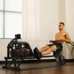 Man rowing the Sunny Obsidian Surge water rower on a yoga mat