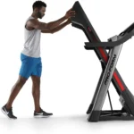 Man folding up the deck of the ProForm Pro SpaceSaver treadmill to demonstrate its space-saving design