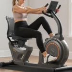 Woman riding the Niceday recumbent exercise bike, rear three-quarter angle showing seat and frame