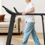 Elderly woman walking on Redliro treadmill, side profile showing low step-on height