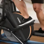 Close-up of a man's legs and pedals on the YOSUDA elliptical mid-stride