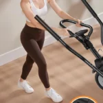 Woman wheeling the YOSUDA elliptical across a room on its front wheels