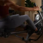 Woman using the Sunny Smart 360 rower console in a home gym