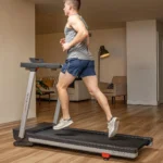 Person running on Sunny SF-T723030 treadmill in a living room setting