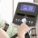 Hand adjusting the resistance dial on the 3G Cardio Elite EM X console