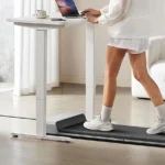 Close view of legs walking on the WalkingPad P1 under a standing desk
