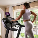Woman running on the Horizon 7.0 AT treadmill at home, rear view