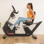 Schwinn 280 Recumbent Bike side profile with a woman pedaling, Schwinn 280 branding visible on frame