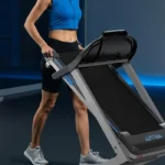 Woman folding and pulling the WELLFIT Heavy Duty treadmill across the floor