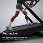 Runner's feet on the Peloton Tread belt demonstrating auto-incline syncing to instructor cues