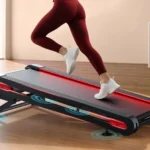 Close-up of legs running on the Jogwell 12/20 extra-wide walking pad showing the dual-alloy frame edge