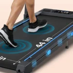 Close-up of feet on the cushioned running belt of the WELLFIT 400+ lb treadmill showing the 44 inch belt length