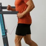 Side profile of a man running on the WELLFIT 400+ lb foldable treadmill with adjustable handrail height markers