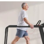 Redliro 400 lb senior walking treadmill set up in a home gym next to a dumbbell rack