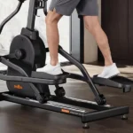 Close-up of a man's legs and pedals mid-stride on the THERUN elliptical, BE506P nameplate visible