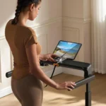 Person using the WalkingPad MX8 Plus console and device tray, hands on the adjustable handles