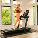 Woman running on BowFlex T16 treadmill in a bright living room