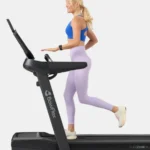 Woman running on BowFlex T16 treadmill, studio side profile