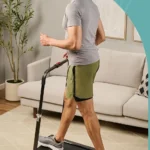Rear view of a man walking on the Lifepro PacerMini incline walking pad with the handlebar raised