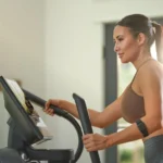 Close-up of hands on the NordicTrack X16 touchscreen console and handlebar