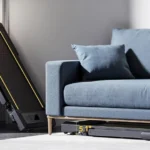 TOPUTURE treadmill folded upright and stored under a sofa, showing low profile