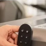 Close-up of hand attaching the magnetic wireless remote to the MERACH UltraWalk W60 walking pad