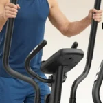 Close-up of a man gripping the ANCHEER elliptical handlebars near the console