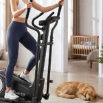 Woman using the ANCHEER elliptical trainer near a nursery, dog sleeping nearby