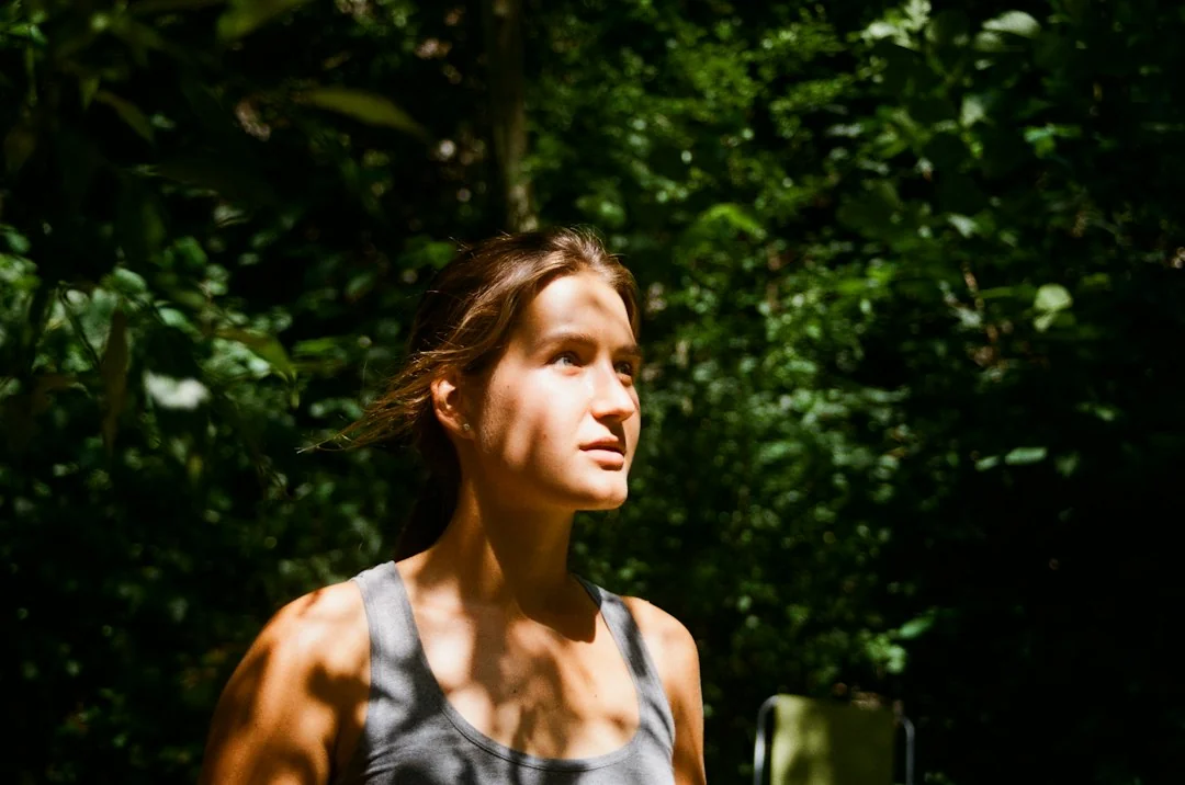 Athletic person in a tank top outdoors, looking focused after a workout