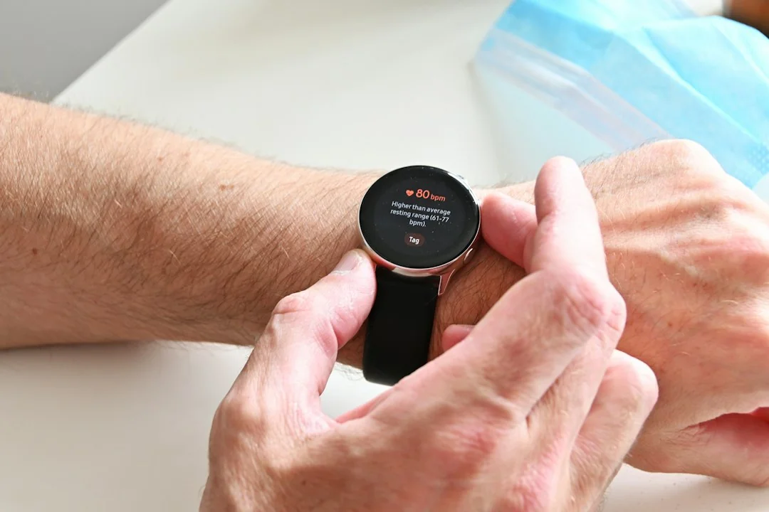 Person reading health data on a smartwatch showing vital sign readings on the wrist
