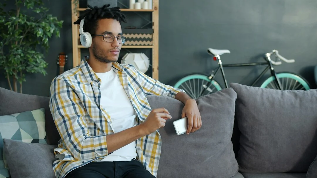 Man relaxing on a couch checking his smartwatch in a casual home setting