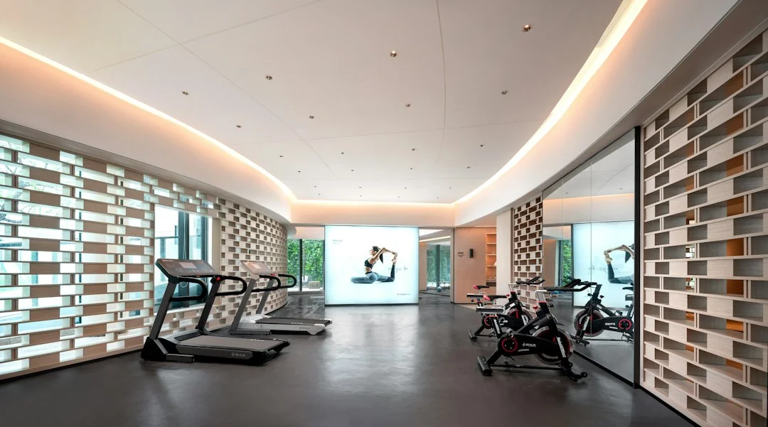 Bright modern home gym with spin bikes and treadmills on a polished floor