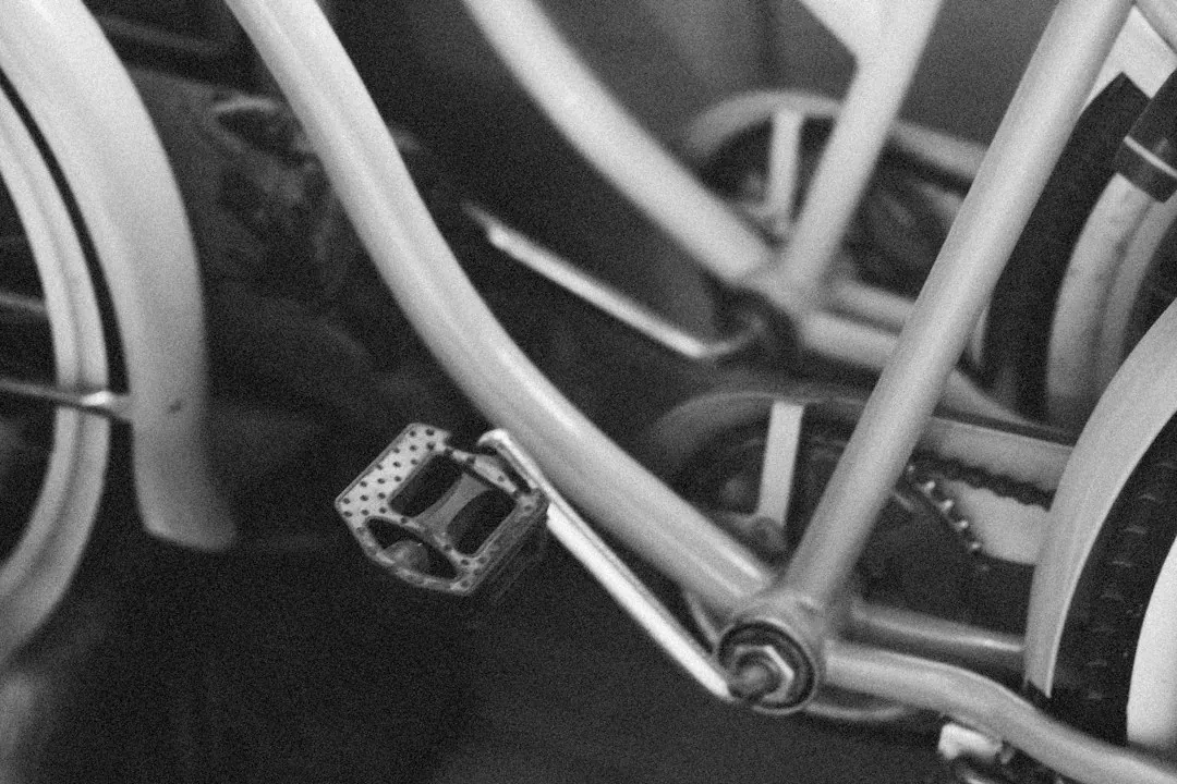 Close-up of a bicycle pedal and metal frame in black and white