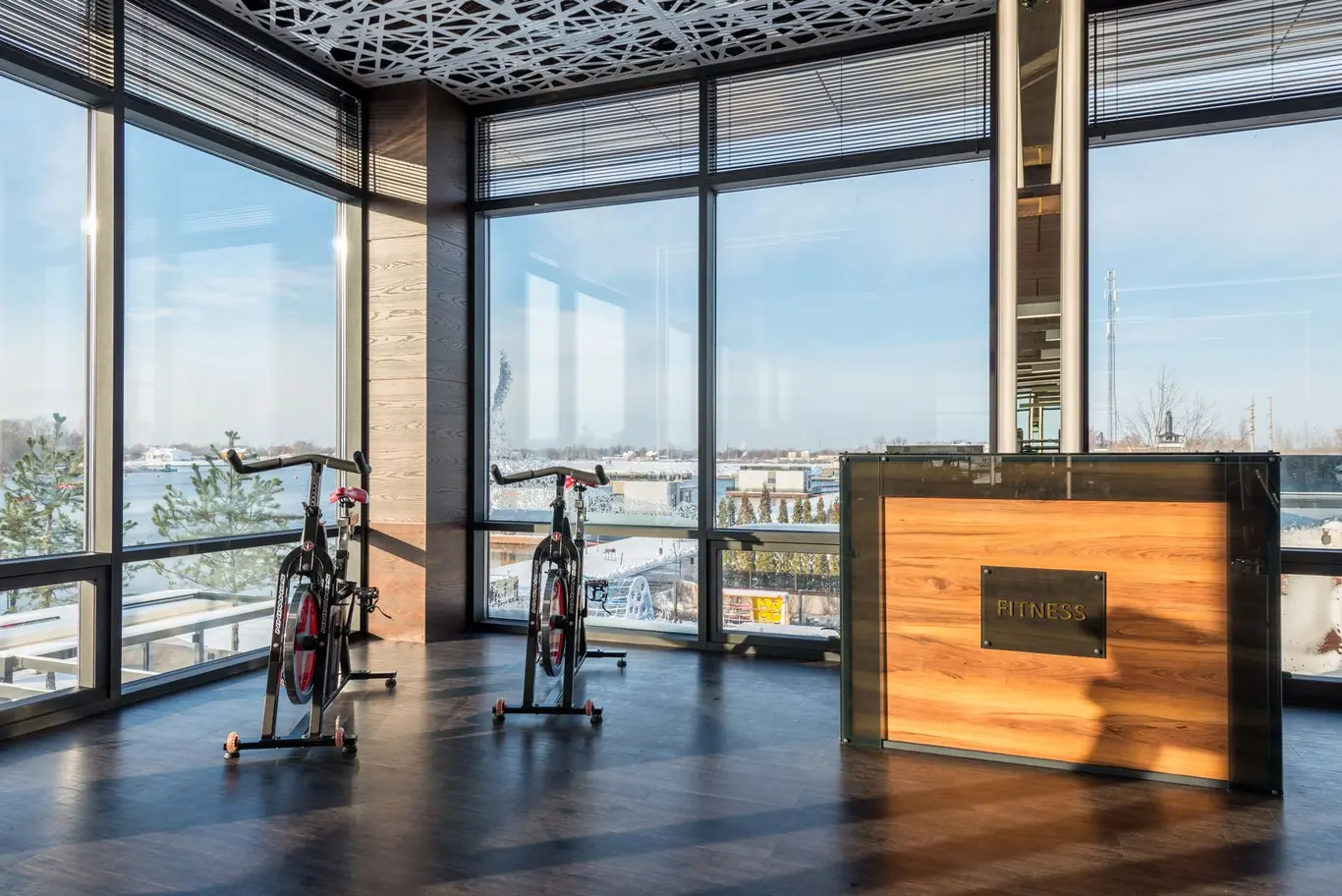 Two spin bikes in a bright modern fitness room with floor-to-ceiling windows