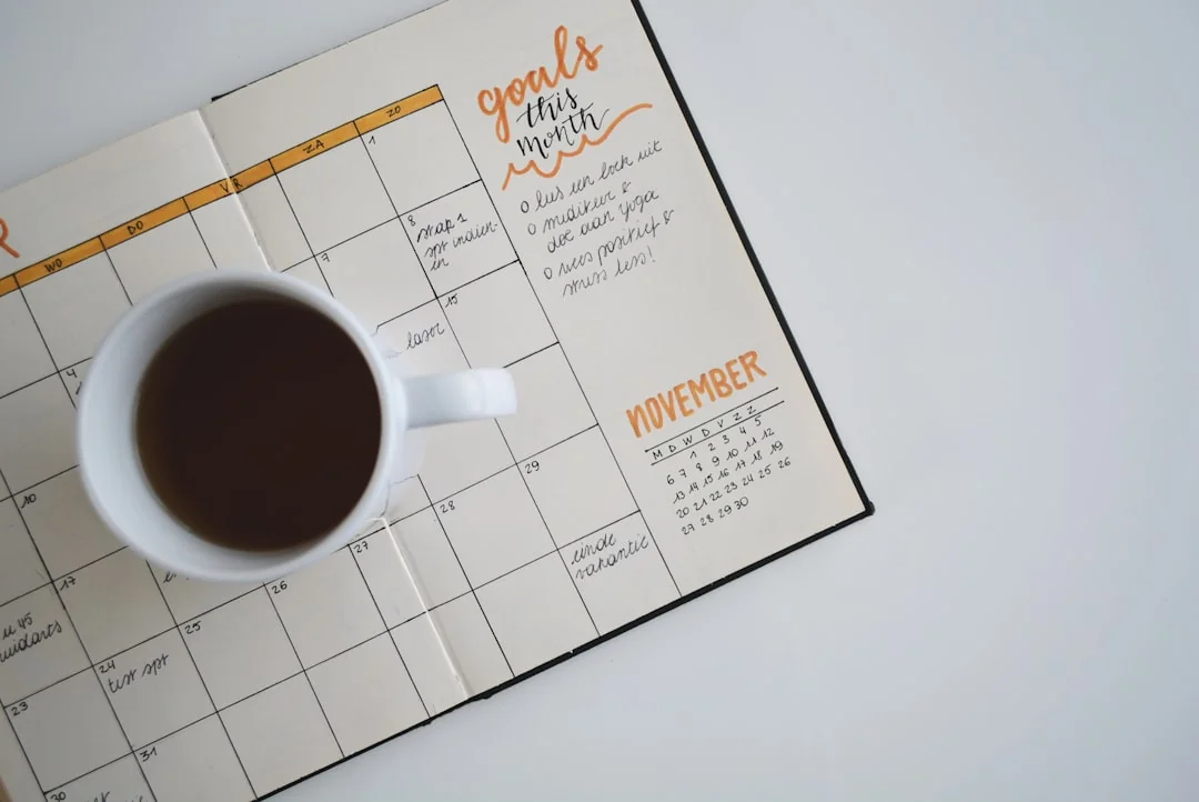 Open planner notebook with a coffee cup showing goals and November calendar