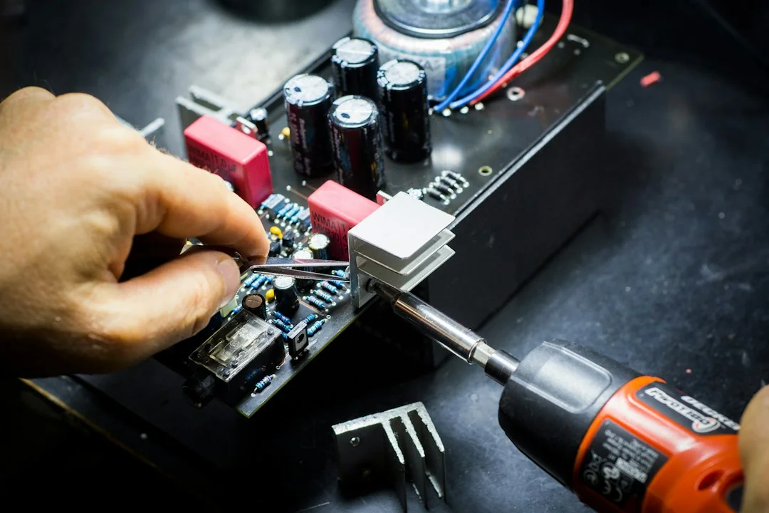 Technician's hand working on an electronic control board during repair
