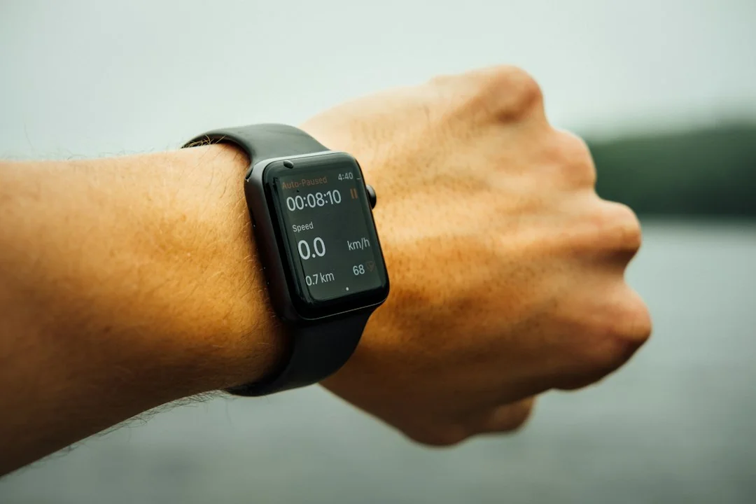 Close-up of an Apple Watch on a wrist displaying speed and fitness tracking data outdoors