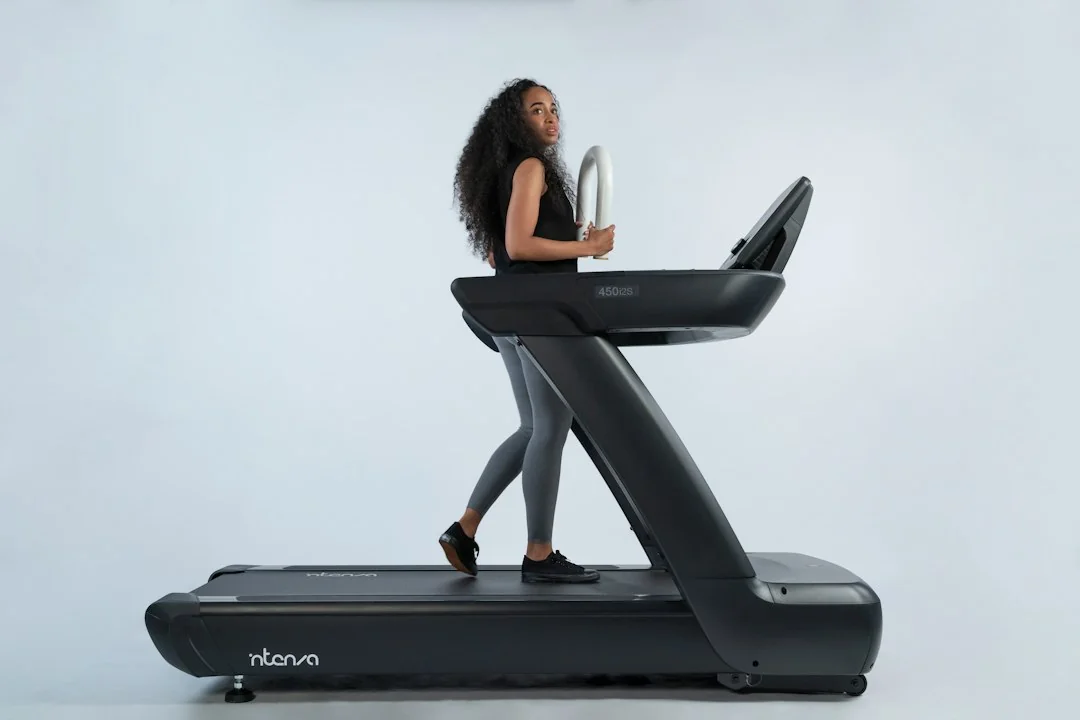Woman walking on a Nkorva treadmill against a clean white studio background