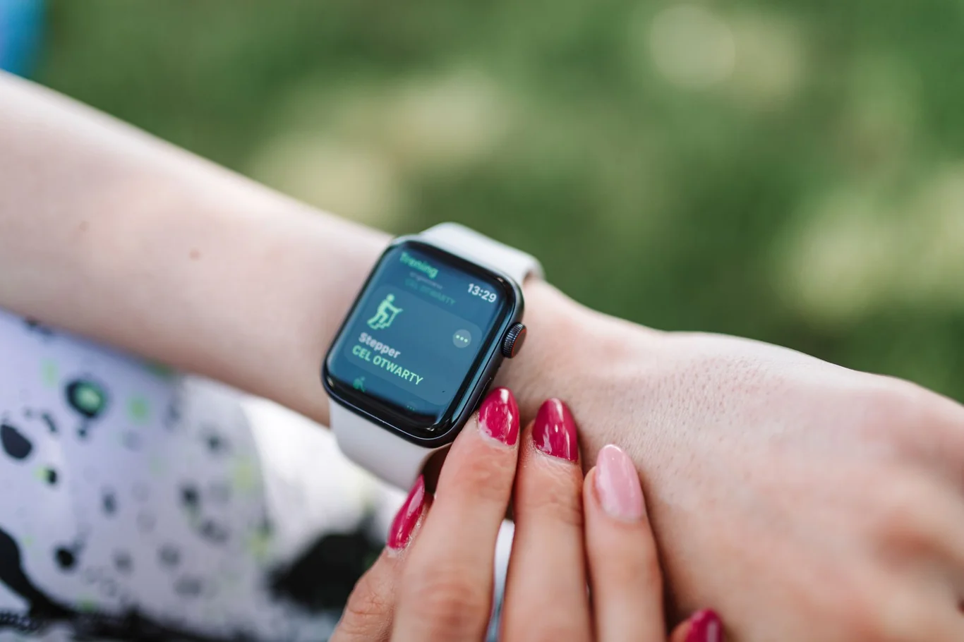 Apple Watch on a woman's wrist displaying a workout screen in an outdoor setting